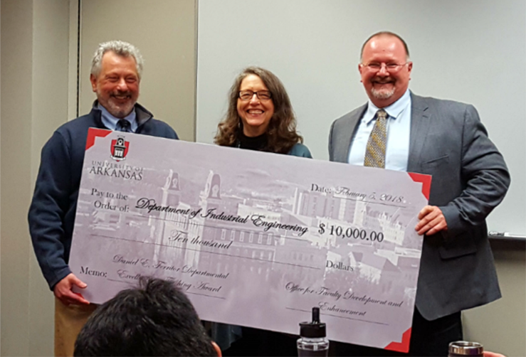 Photo of three people with large check