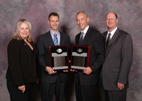 Photo of Russell Meller and Kevin Gue with plaques