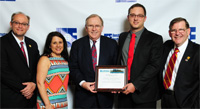 Photo of Jordan Sonnetag with Kim Needy, John White and leadership of IIE